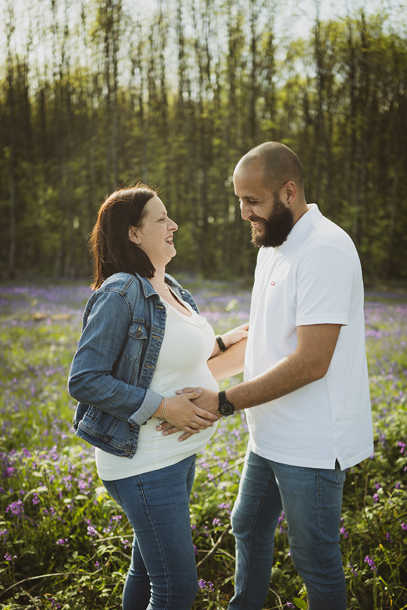 © Emilie Brosseau - Photo couple qui rigole dans une clairière de clochettes violettes © Emilie Brosseau - Photo couple qui rigole dans une clairière de clochettes violettes